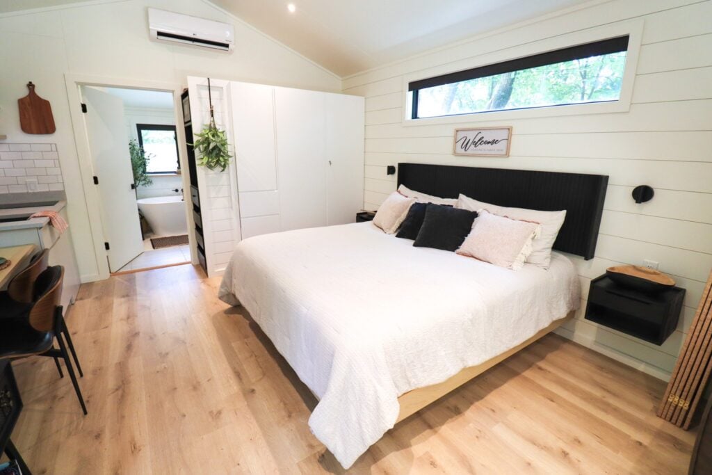 The bedroom with its king bed and wood floors