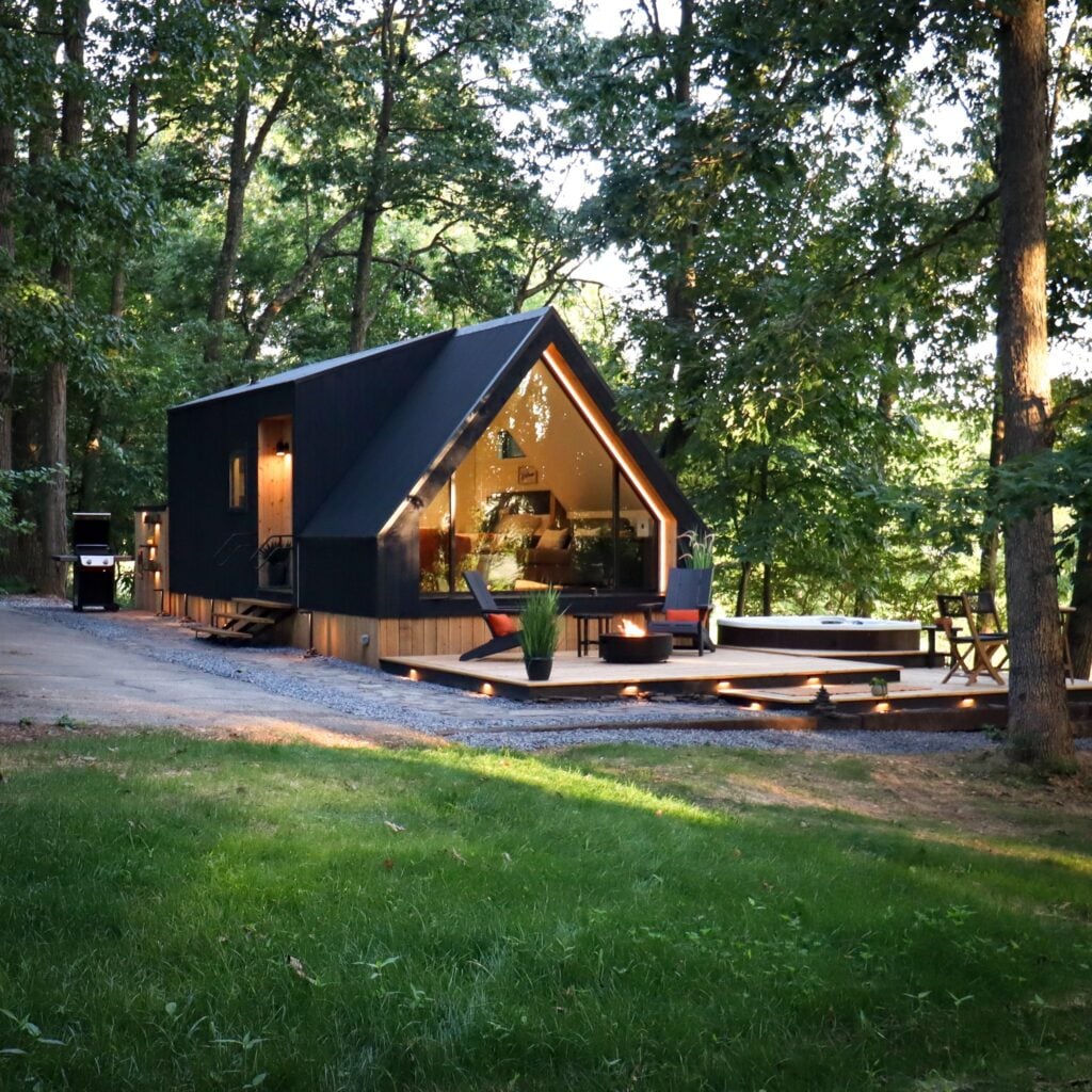 The cabin seen from the gravel driveway at dusk