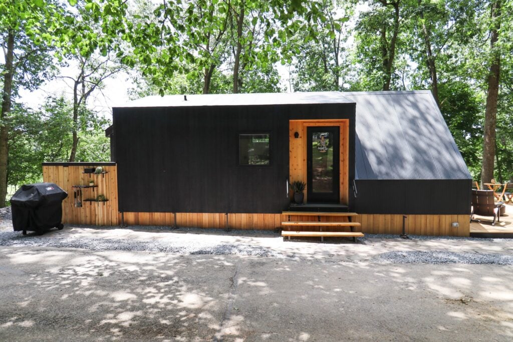 The side of the cabin showing its black cladding and wood detailing