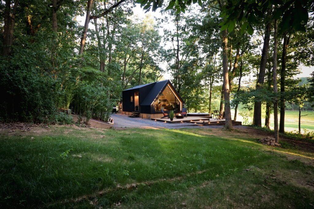 The cabin seen across the lawn, framed by trees